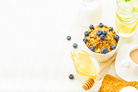 Healthy breakfast with granola, honey and milk on white background with copy space, horizontal shotの写真素材