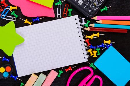 Different stationaries on black table with copy space in notebook. Back to school conceptの写真素材