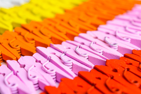 Background of colorful wooden small pegs lines with selective focusの写真素材