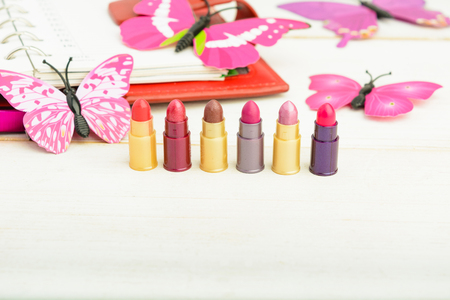 Test lipsticks with red organizer over white wooden background with copy spaceの写真素材
