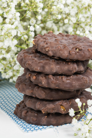 Cookies stack on tissue over white background with small flowers, vertical shotの写真素材
