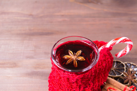 Closeup view of mulled wine decorated with lollypop over brown wooden background with copy space, closeup viewの写真素材