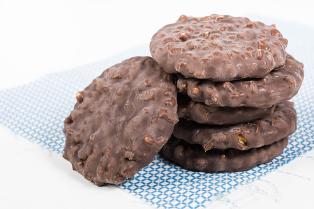 Stack of chocolate nut cookies on raw material over white backgroundの写真素材