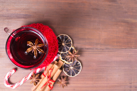 Overhead view of christmas hot drink with citrus and cinnamon over brown wooden background with copy space, overhead viewの写真素材