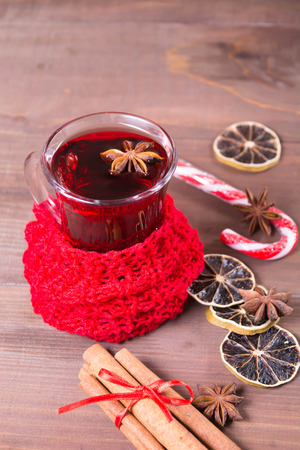 Hot mulled wine drink with citrus, anise and cinnamon over brown wooden background, vertical shotの写真素材