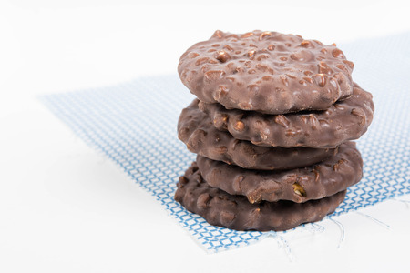Stack of chocolate nut cookies on raw material over white backgroundの写真素材