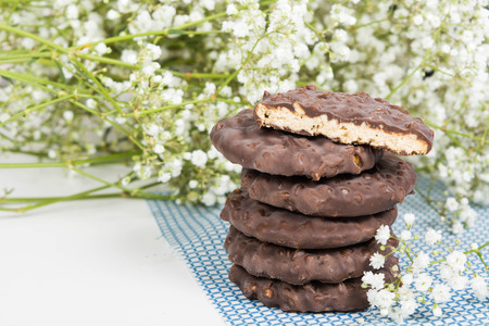 Cookies stack on tissue over white background with small flowersの写真素材
