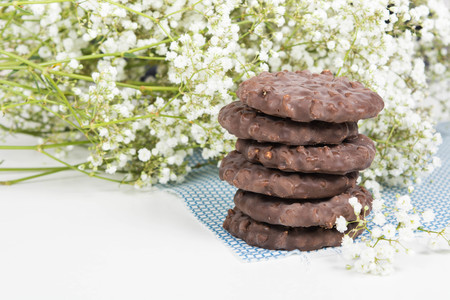 Cookies stack on tissue over white background with small flowersの写真素材
