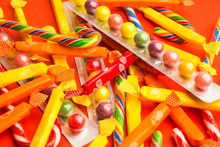 Different candies in packs on red backgroundの写真素材