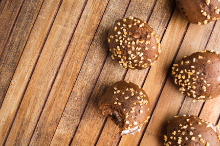 Group of chocolate cookies with cream and nuts over wooden table, overhead view with copy spaceの写真素材