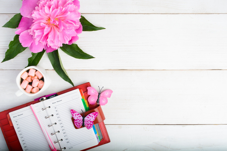 Woman planning concept (organizer, flower and coffee with marsmallow) over wooden table with copy spaceの写真素材