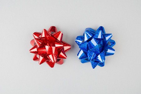 Red and blue festive bows over grey background with copy space, overhead viewの写真素材