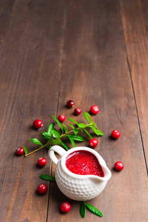 Cranberry sauce on brown wooden background with copy space, vertical shotの写真素材