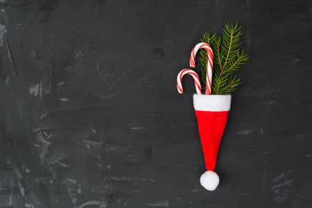 New Year or Christmas symbols with two lollipops, fir tree and Santa's hat with copy space