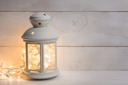 Christmas lantern with garland on white background with copy spaceの写真素材