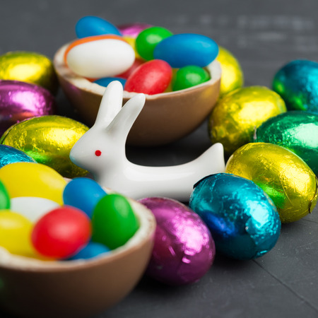 Easter dessert with chocolate eggs and white rabbit in focus, square shot