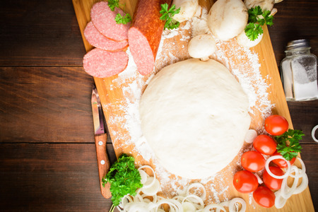 Italian pizza ingredients over wooden board, flat lay, with copy spaceの写真素材