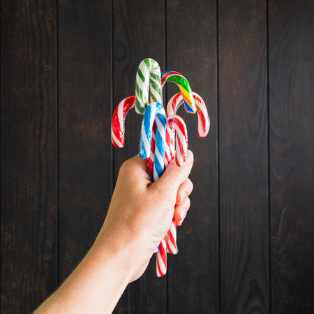 Christmas candies in female hands on dark wooden background with copy spaceの写真素材