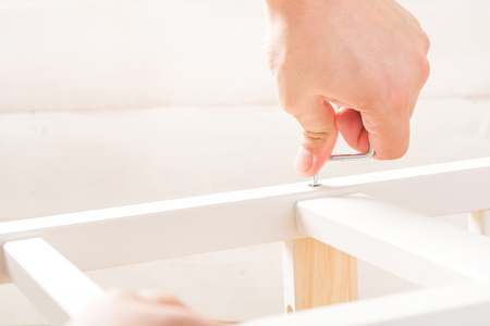 Man is assembling of furniture with copy space on white backgroundの写真素材