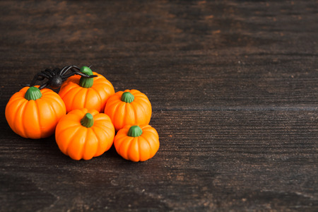 Five orange fake pumpkins with black spider on wooden table, halloween decorationの写真素材