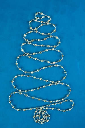 Christmas decoration tree of silver shine garland over blue backgroundの写真素材
