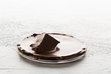 Melting chocolate on plate over white texture background with copy spaceの写真素材