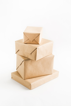 Stack of craft wrapped boxes for delivery on white background