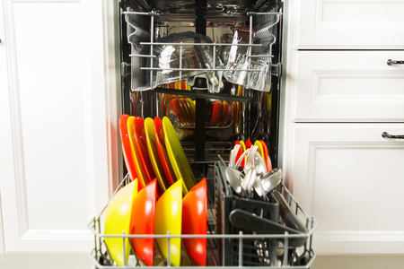 Dishwasher with colorful dish in it in the white kitchenの写真素材