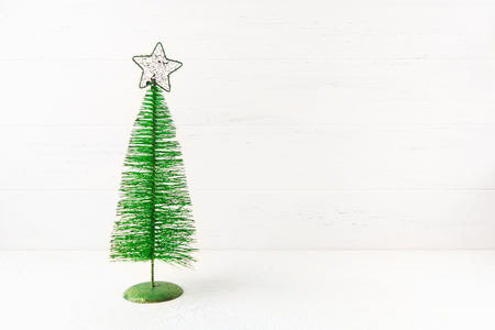 Metal Christmas tree on white wooden background with copy spaceの写真素材