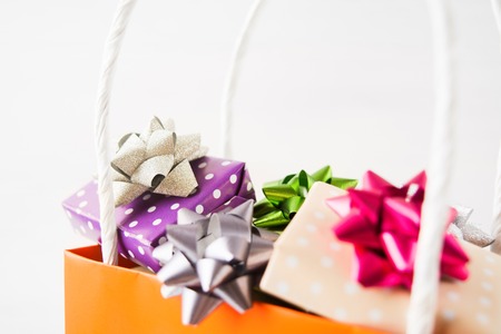 Holiday gifts in paper bag, closeup view on white backgroundの写真素材