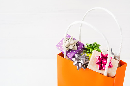 Christmas shopping - paper bag with gifts on white background with copy spaceの写真素材