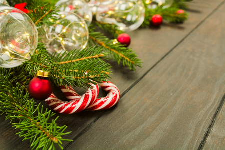 Christmas decoration with green fir tree, candy canes, garland on wooden background with copy spaceの写真素材