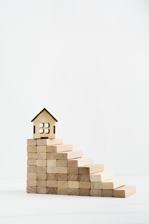 Small wooden house on the top of stairs, business concept, success of career. Vertical shot with copy spaceの写真素材