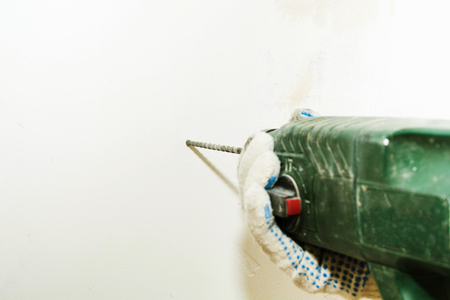 Dirty perforator in male hands with focus on drill with copy spaceの写真素材