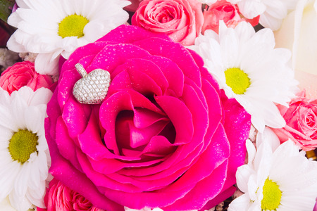 White golden pendant with heart shape over pink rose like love gift concept for Valentine's day or Birthday. Beautiful delicate color bouquet with jeweleryの写真素材