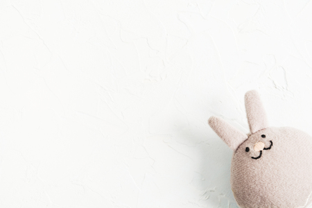 Funny textile rabbit on white stone background in rifht coner with copy space, flat lay, Easter conceptの写真素材
