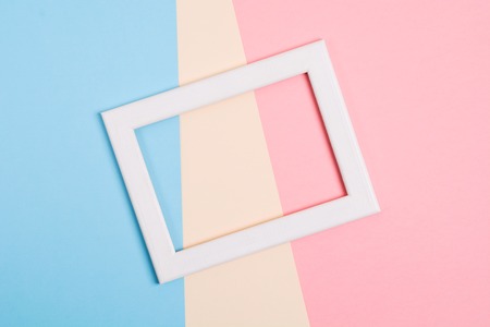 Colorful paper background with white wooden frame, flat lay style with modern colorsの写真素材