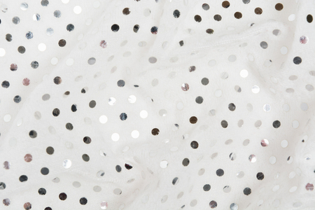 Closeup iew of white fabric textile material with silver sequins. Glamour metal glitter background. Flat lay. Copy spaceの写真素材