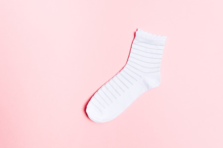 New white socks for feet with shiny striped pattern over pastel pink background with copy space. clothes for legsの写真素材