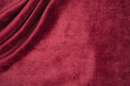 Textile waves on red velvet background with copy space. Flat layの写真素材
