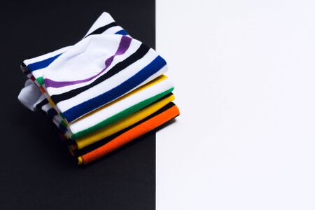 Colorful fashionable striped white and black socks over white and black background. Selective focus. Bright clothes for feetの写真素材
