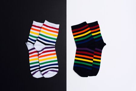 Two negative white and black background with two pair of socks with colorful striped pattern. Flat layの写真素材