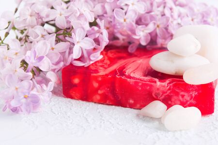 Beautiful lilac flowers, handmade soap and stones for spa and aromatherapy over white textured background. Selective focusの写真素材