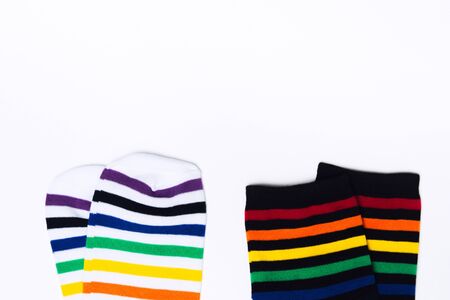 Two clean white and black pair of socks with striped pattern on white background with copy space. Flat lay. Top view. Fabric cotton clothes for feet. Hipster fashionの写真素材