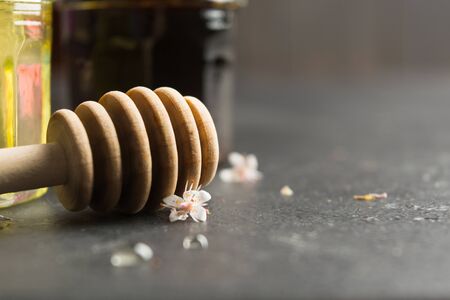 Wooden stick for honey with two type of honey on background. Healthy organic food with eco spoon. Selective focus. Autumn season. Copy spaceの写真素材