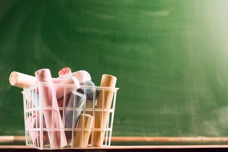 Many colorful piece of chalk in plastic basket. Back to school concept. Beginning school year....