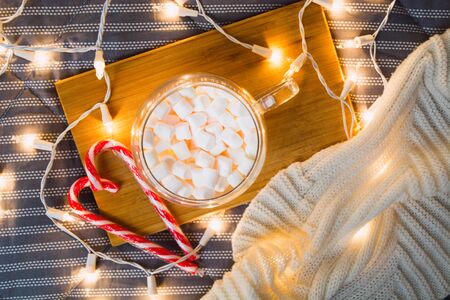 Christmas beautiful card with marshmallows and heart of candy canes. Cozy home. Valentine's day concept with lights and plaid. Flat lay. Top viewの写真素材