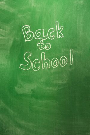 Back to school concept with written words in chalk on green blackboard. The beginning of the school year. copy space. Vertical shotの写真素材