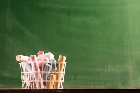 Many colorful piece of chalk in plastic basket. Back to school concept. Beginning school year. Selective focusの写真素材