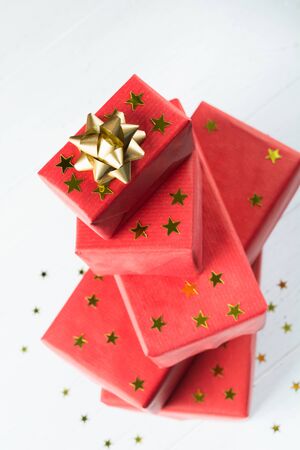 Top view of holday gift boxes in red paper with golden stars and bow. Vertical shotの写真素材